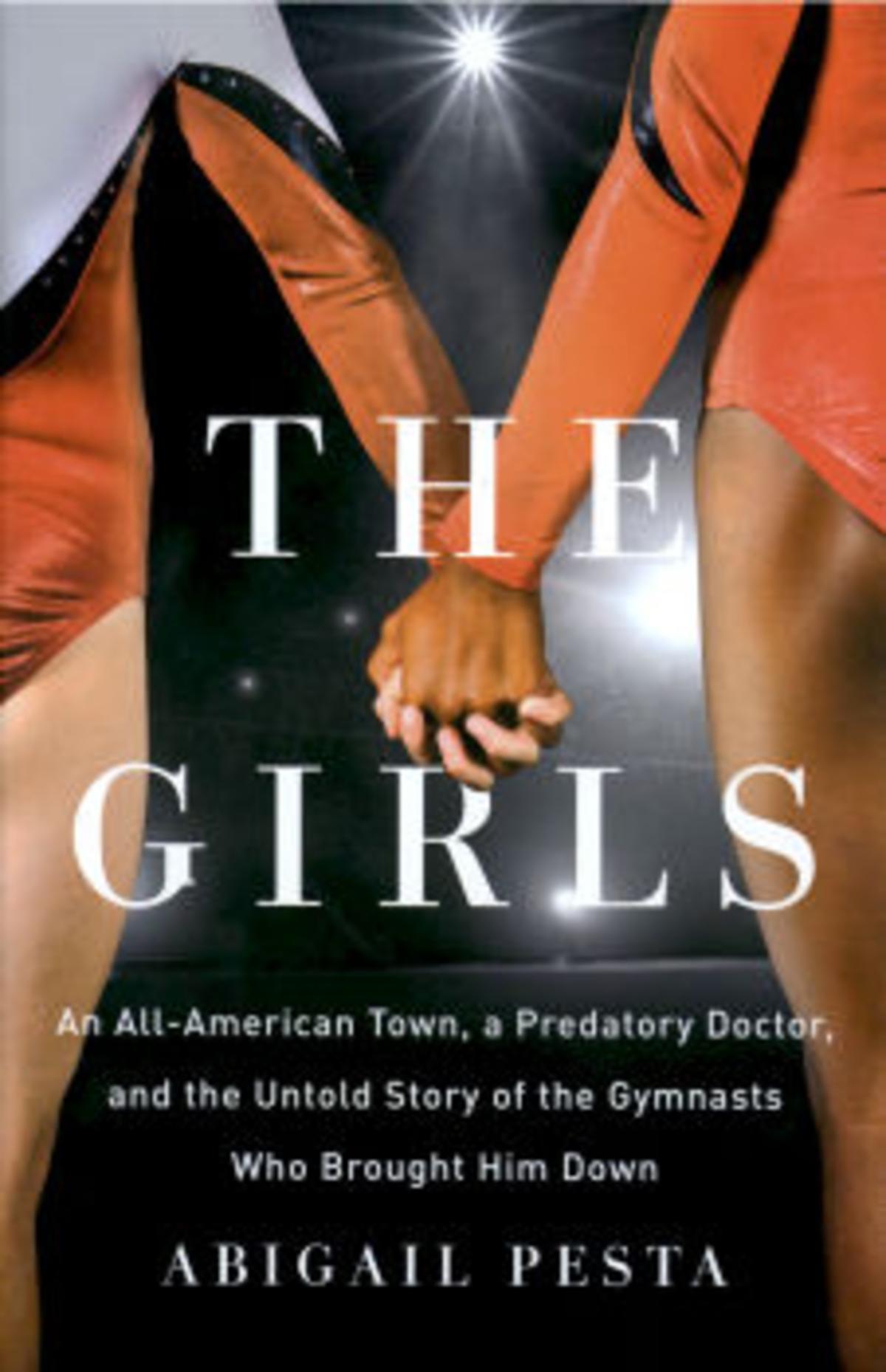 The cover of The Girls by Abigail Pesta shows a close-up of a white athlete and a Black athlete holding hands. They are wearing leotards. Cameras are flashing in front of them.